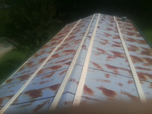 Rusted metal roof panels with new wood purlins before replacement — Storm Damage Roof Repair in Lawton by Roofing Brothers
