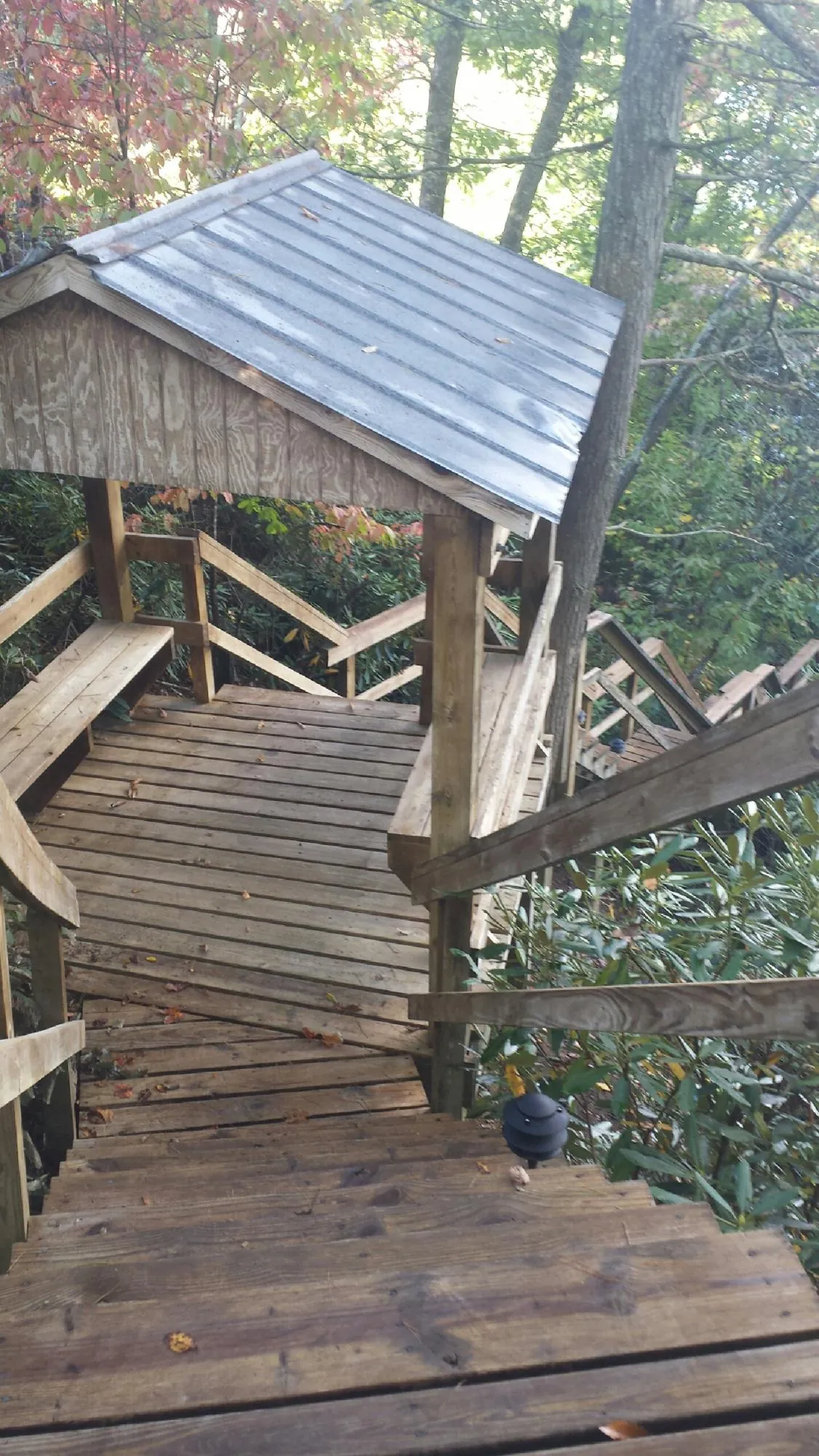 Metal roofed shelter over wooden steps on a wooded walkway — Skylight Repair & Installation work by our crew in Lawton