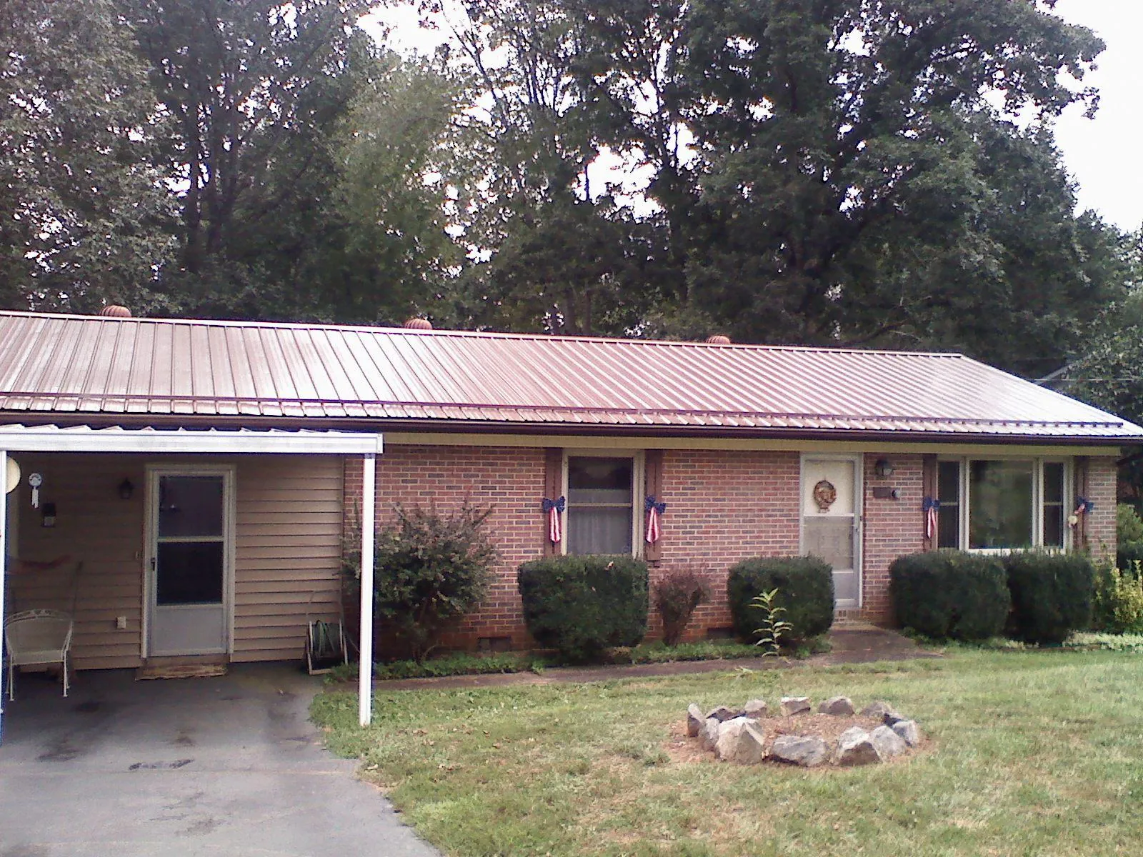 Bronze metal roof and carport on a brick ranch home — Roof Repair work by our crew in Lawton